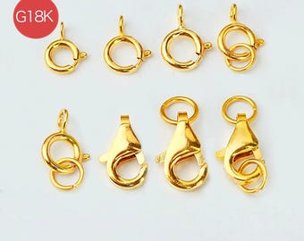 May include: A collection of gold-colored jewelry clasps and connectors, including lobster claw clasps and spring ring clasps. The clasps are in various sizes and styles, with a bright, reflective finish. A red circle with the text "G18K" is in the upper left corner.