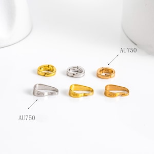 May include: A collection of six small, gold, silver, and rose gold-colored earrings. The earrings are in various shapes, including hoops and curved designs. The text "AU750" is visible on some of the earrings.