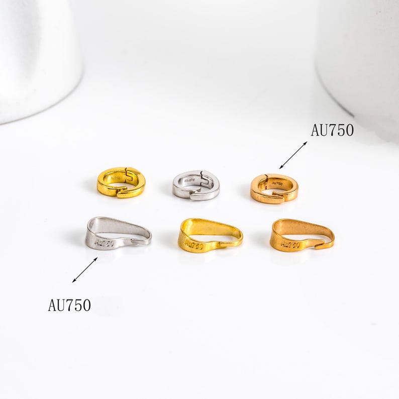 May include: A collection of six small, gold, silver, and rose gold-colored earrings. The earrings are in various shapes, including hoops and curved designs. The text "AU750" is visible on some of the earrings.