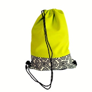 Può includere: Una borsa a cordoncino verde lime con un motivo geometrico bianco e nero sul fondo.