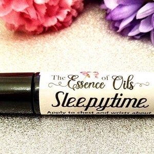May include: A black roller bottle with a white label that reads "The Essence of Oils Sleepytime Apply to chest and wrists about".