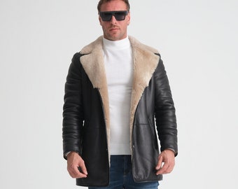 May include: A black leather jacket with a light brown shearling collar and lining. The jacket has a zipper closure and two front pockets. The model is wearing blue jeans and white sneakers.