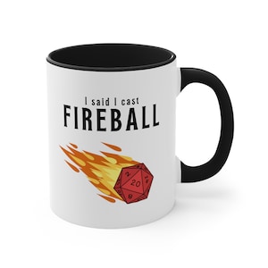 A white ceramic mug with a flaming D20 on it for dungeons and dragons DnD that says I didnt ask how big the room is on one side and I said I cast FIREBALL on the other