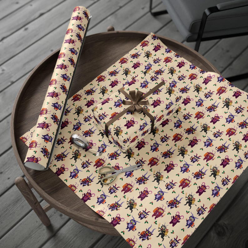 Krampus wrapping paper unrolled on table beside scissors and ribbon