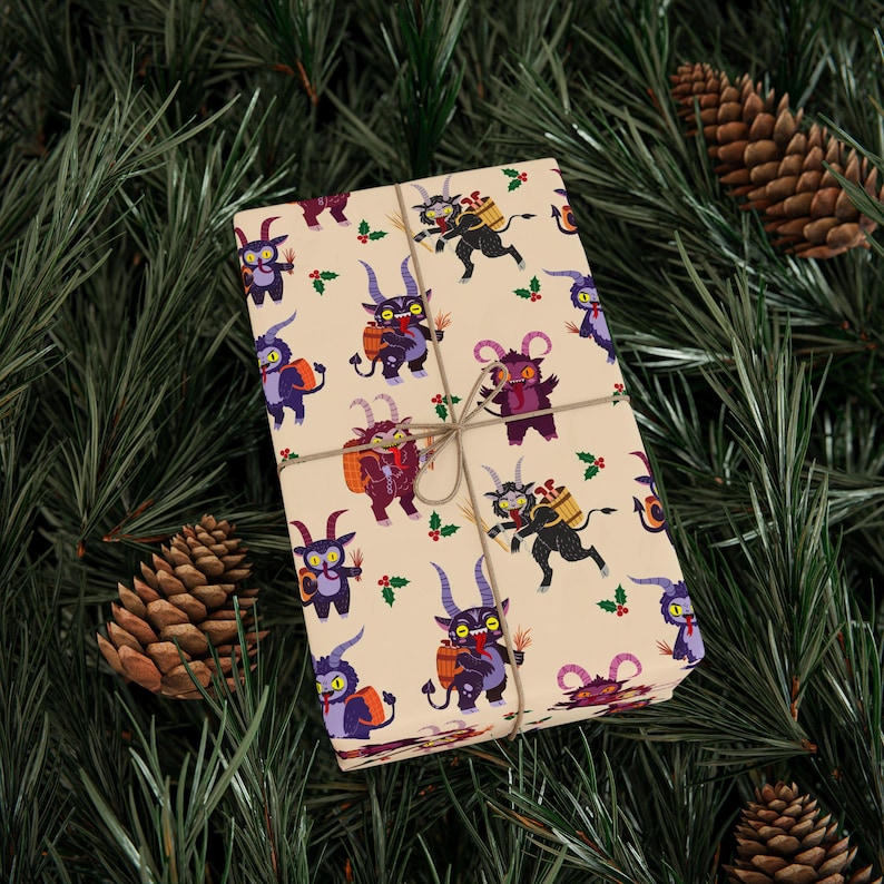Wrapped gift box with Krampus wrapping paper surrounded by pinecones on greenery