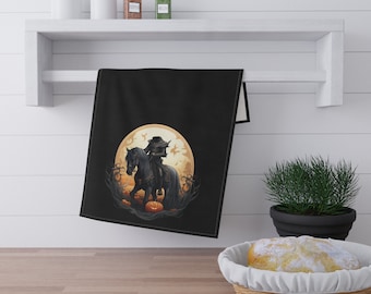 May include: Black kitchen towel with a Halloween design featuring a rider on a black horse in front of a full moon with pumpkins.