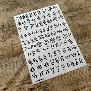 May include: A white sheet of paper with black symbols printed on it. The symbols are various shapes and designs, including circles, squares, triangles, and stars. The paper is labeled "brisklychay" in the bottom right corner.