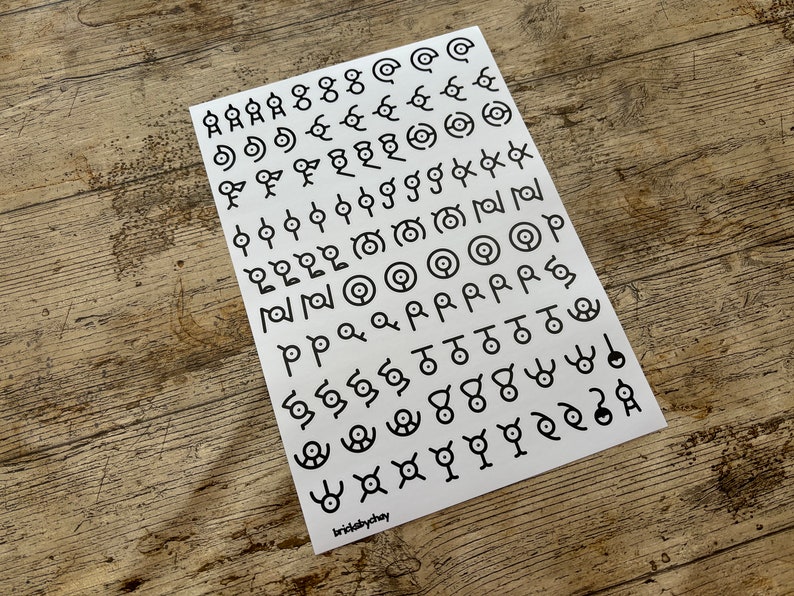 May include: A white sheet of paper with black symbols printed on it. The symbols are various shapes and designs, including circles, squares, triangles, and stars. The paper is labeled "brisklychay" in the bottom right corner.