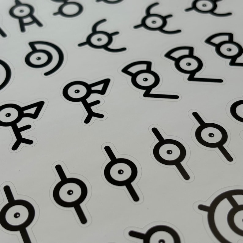 May include: A sheet of black and white stickers featuring various designs, including a stylized eye with a line through it, a bird-like creature, and a stylized eye with a curved line through it.