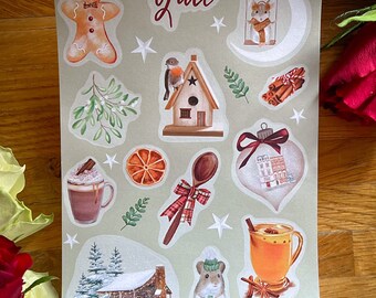 Può includere: Un foglio di adesivi a tema Yule. Gli adesivi presentano illustrazioni di un omino di pan di zenzero, una casetta per uccelli, una capanna nel bosco, un topo, una tazza di cioccolata calda, una tazza di sidro, un cucchiaio di legno, un bastoncino di cannella, una stella, un ramo di vischio, una fetta d'arancia e un ornamento natalizio.