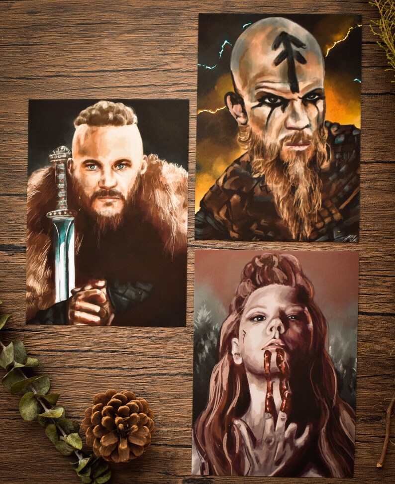 May include: Three digital art prints featuring characters from the TV show Vikings. The first print shows a man with a beard and a sword. The second print shows a man with a beard and a rune on his forehead. The third print shows a woman with red hair and blood on her hands.