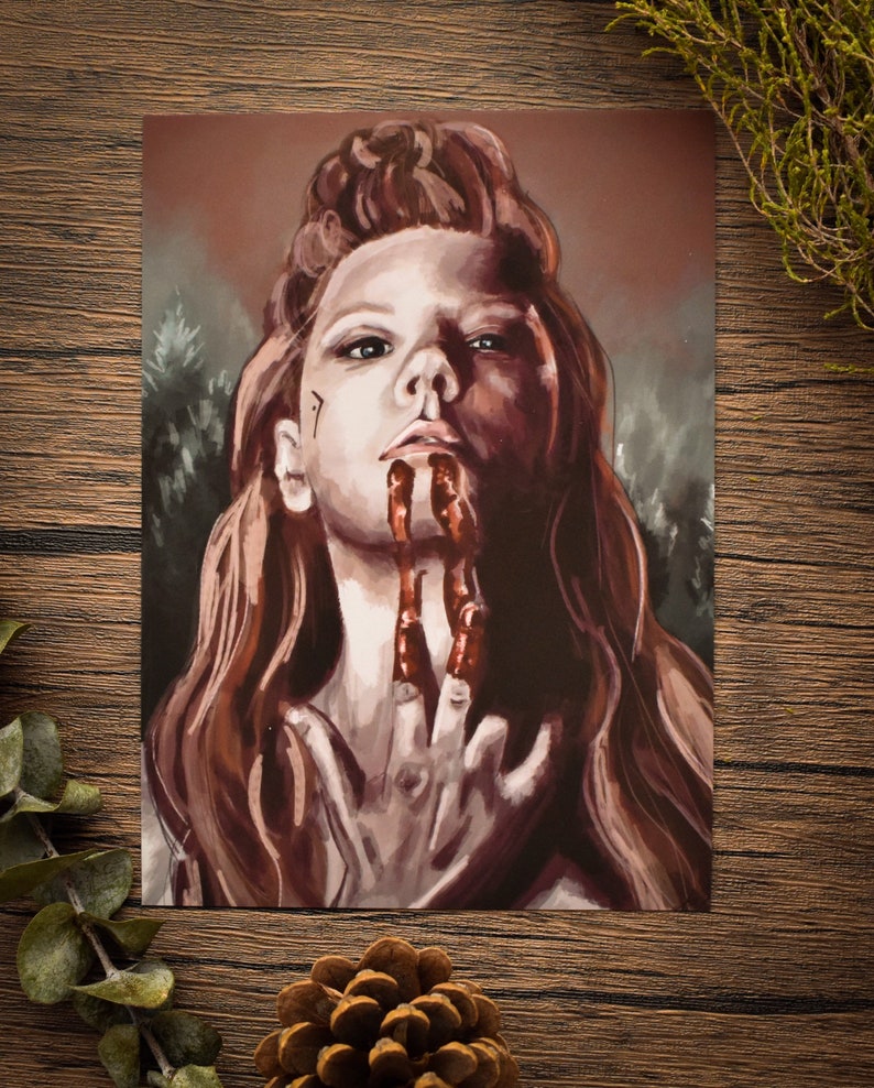 May include: A painting of a woman with long red hair, wearing a dark brown outfit. Her face is painted with a red, bloody design, and her hands are covered in blood.