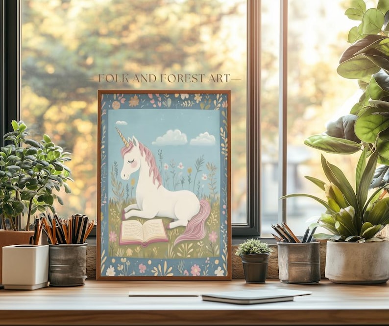 May include: A framed print featuring a white unicorn with a pink mane and tail, reading a book in a field of flowers under a blue sky with clouds. The print is labeled "FOLK AND FOREST ART".