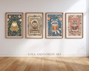 May include: Four framed art prints featuring whimsical animal illustrations. A frog, hedgehog, raccoon, and mouse are depicted reading books, surrounded by floral borders. The prints have a vintage aesthetic with a dark teal background. The text "FOLK AND FOREST ART" is below the prints.