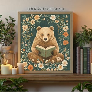 A cozy folk art illustration featuring a brown bear sitting among wildflowers, holding an ornate green book. The green background complements the warm tones of the bear and florals. Perfect for book lovers, woodland nursery decor, and cottagecore.