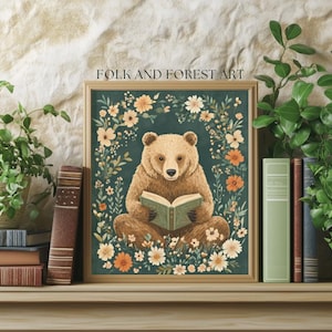 A cozy folk art illustration featuring a brown bear sitting among wildflowers, holding an ornate green book. The green background complements the warm tones of the bear and florals. Perfect for book lovers, woodland nursery decor, and cottagecore.