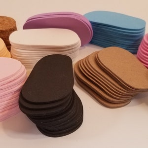May include: Stacks of oval-shaped foam pads in various colors, including light pink, peach, light blue, lavender, brown, black, and white.