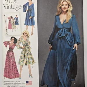 May include: Vintage Simplicity sewing pattern from the 1970s. The pattern features illustrations of several long dresses, including a blue wrap dress with a bow and long sleeves. The text "1970s Vintage" is at the top.