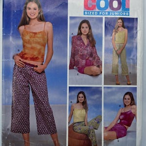 May include: A sewing pattern showing various outfits, including a camisole and wide-leg trousers with a floral design. The pattern also features a button-down shirt and shorts, and a camisole with matching shorts. The word "COOL" is displayed in large, colourful letters.