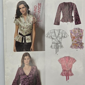 May include: New Look sewing pattern 6755 for a wrap-style top with a tie waist. The envelope displays four variations of the top with different sleeve lengths and floral or abstract patterns, including size range A 8-18, FR 36-46, and EUR 34-44.