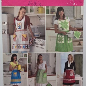 May include: A Simplicity pattern sheet featuring various apron designs. The aprons showcase diverse patterns, including geometric shapes, stars, and polka dots, in colors like red, blue, green, and yellow. The sheet includes the name "Wettie" and the number "2980".