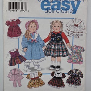 May include: Simplicity pattern 9381 for doll clothes. The package shows illustrations of doll outfits, including dresses and tops, in various colours and patterns. The text "design your own easy doll clothes" is visible.