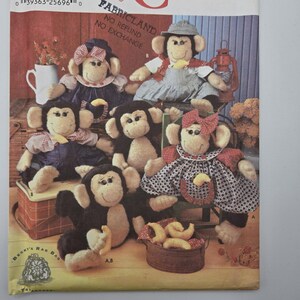 Può includere: Una collezione di bambole a forma di scimmia fatte a mano, ognuna con abiti ed espressioni uniche. Le scimmie sono in varie pose, alcune sedute e altre che tengono oggetti. L'immagine è un modello vintage per realizzare le bambole.