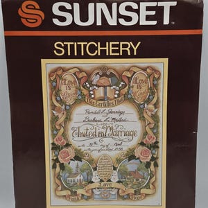 Peut inclure: Kit de certificat de mariage Sunset Stitchery. Le kit présente un fond marron avec les mots "Sunset Stitchery" en blanc et orange. Le certificat est orné de motifs floraux et de rubans, et du texte "United in Marriage".