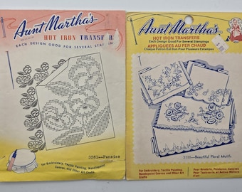 May include: Two vintage Aunt Martha's Hot Iron Transfer packets. One features a pansy design, the other showcases beautiful floral motifs. The packets are yellowed with age, with text in English and French. Ideal for embroidery, textile painting, and needlepoint.