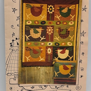 May include: A quilt pattern featuring colorful chicken designs. The quilt has a wooden frame and includes the text "Meme's Quilts" and "Spring Chickens MQ#195". The chickens are in various colors and patterns, with floral accents.