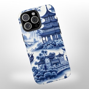 May include: A white phone case with a blue and white pattern of Chinese pagodas, bridges, and trees. The case has a cutout for the phone's camera.