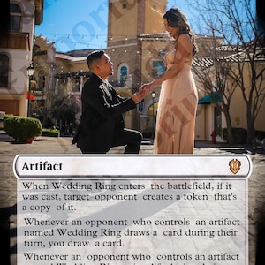 May include: A Magic: The Gathering card with a white background and a picture of a couple getting engaged. The card is titled "Wedding Ring" and has a mana cost of 2 white mana symbols. The card text reads: "When Wedding Ring enters the battlefield, if it was cast, target opponent creates a token that's a copy of it. Whenever an opponent who controls an artifact named Wedding Ring draws a card during their turn, you draw a card. Whenever an opponent who controls an artifact named Wedding Ring gains life during their turn, you gain that much life."