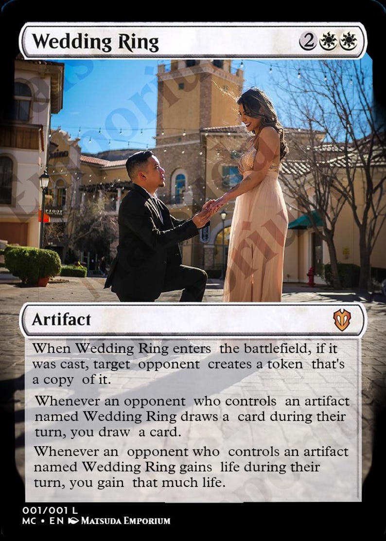 May include: A Magic: The Gathering card with a white background and a picture of a couple getting engaged. The card is titled "Wedding Ring" and has a mana cost of 2 white mana symbols. The card text reads: "When Wedding Ring enters the battlefield, if it was cast, target opponent creates a token that's a copy of it. Whenever an opponent who controls an artifact named Wedding Ring draws a card during their turn, you draw a card. Whenever an opponent who controls an artifact named Wedding Ring gains life during their turn, you gain that much life."