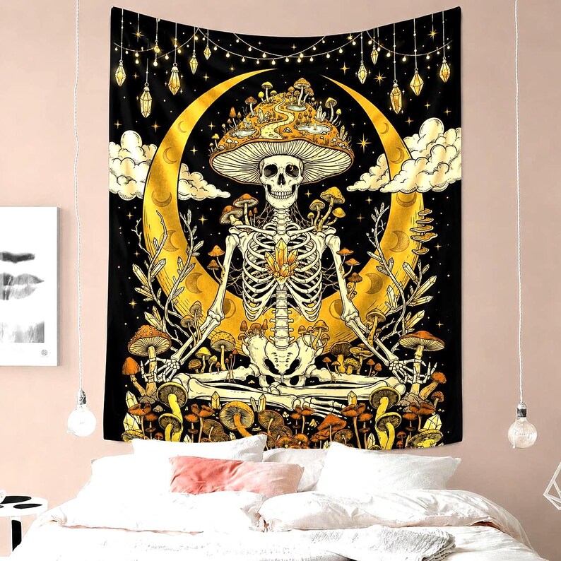 May include: A black tapestry featuring a skeleton meditating in front of a golden crescent moon. The skeleton wears a mushroom cap and is surrounded by mushrooms. The background is a starry night with hanging lights and crystals.