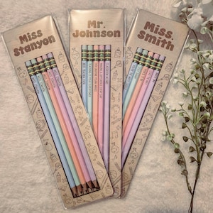 May include: Three sets of pastel-coloured pencils, each in a cardboard sleeve. The pencils are engraved with phrases such as "Best Teacher Ever" and "You Inspire Young Minds." The packaging is labelled with names like "Miss Stanyon" and "Mr. Johnson."