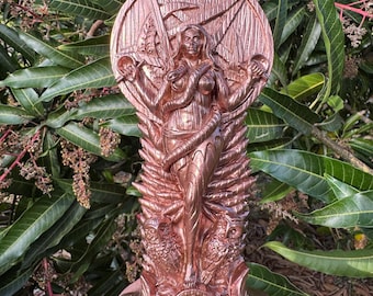 May include: A copper-colored statue of a female figure with a snake wrapped around her. The figure is holding a sword in one hand and a shield in the other. The statue is standing on a base with a circular design.