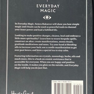 May include: A black and white book cover with the title "Everyday Magic" in white text. The book cover features a stylized eye symbol and text about using simple magic and rituals to channel inner power and lead a fulfilled life. The book is by Semra Haksever and published by Hardie Grant Books.