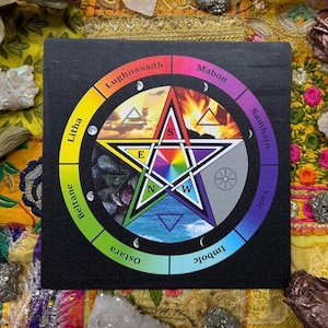 May include: A black square with a colorful pentagram design. The pentagram is surrounded by a rainbow-colored ring with seasonal names. The center of the pentagram features a rainbow star and symbols representing earth, air, fire, and water.