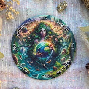 May include: A round, colorful divination board featuring a woman with green hair holding a globe. The board has text that says "Yes", "Maybe", "No", and "Rephrase". The artwork includes animals and nature elements.