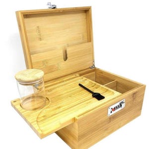 May include: A wooden box with a lock and a tray for rolling. The box has a compartment for storing items and a glass jar with a lid.