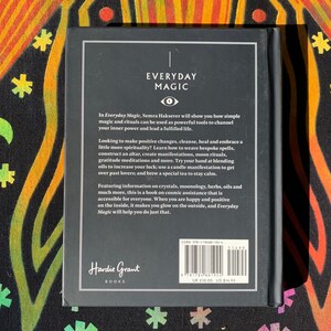 May include: Black and white book cover with the title "Everyday Magic" in white text. The book cover features a stylized eye symbol and text about simple magic and rituals. The back cover includes the book title, author, publisher, ISBN, and price in UK pounds.