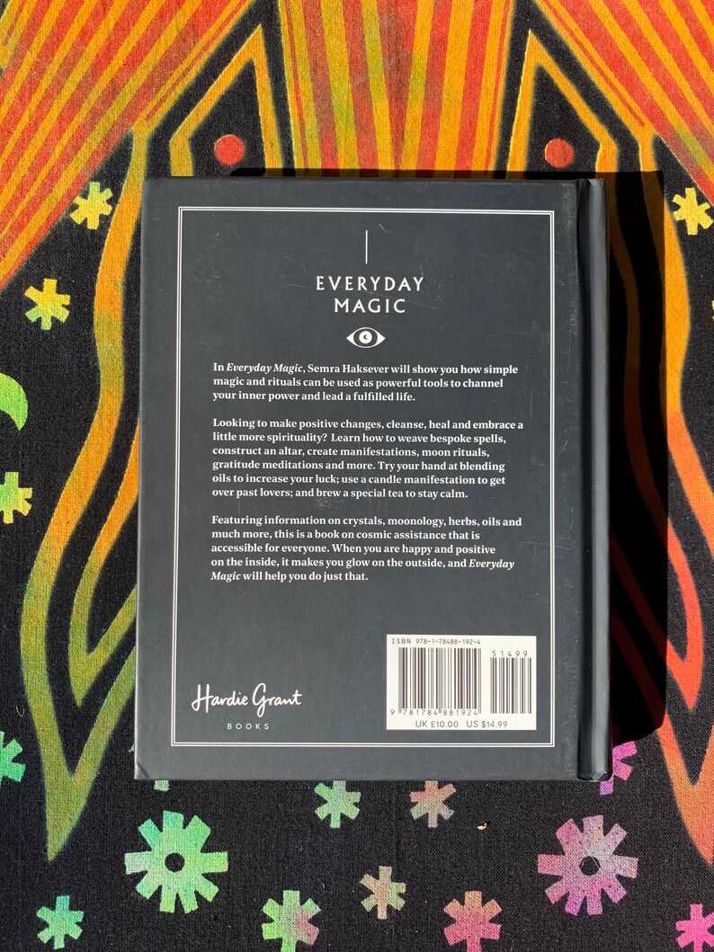 May include: Black and white book cover with the title "Everyday Magic" in white text. The book cover features a stylized eye symbol and text about simple magic and rituals. The back cover includes the book title, author, publisher, ISBN, and price in UK pounds.