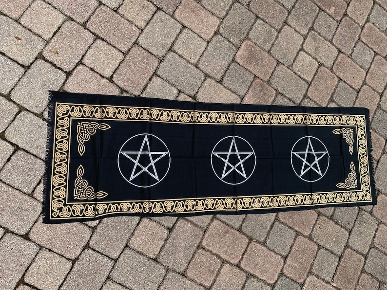 May include: Black altar cloth with a gold Celtic knot border and three silver pentagrams.