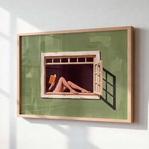 May include: A framed wall art print featuring a sage green wall with a white window frame. Inside the window, a figure reclines whilst reading an orange book. The scene includes a partially open window pane casting a dark shadow on the green wall.