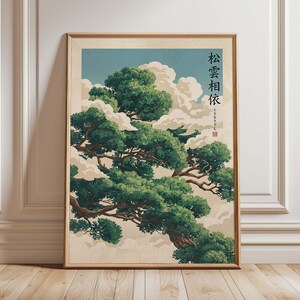 May include: A framed art print featuring a Japanese-style illustration of a pine tree with green foliage and brown branches. The tree is set against a backdrop of white clouds and a light blue sky. Japanese characters are visible on the right side of the print.