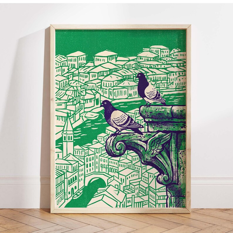 May include: A framed art print featuring a green and white illustration of a cityscape with two pigeons perched on a decorative ledge. The artwork has a vintage, linocut style, with a green background and a light wood frame.