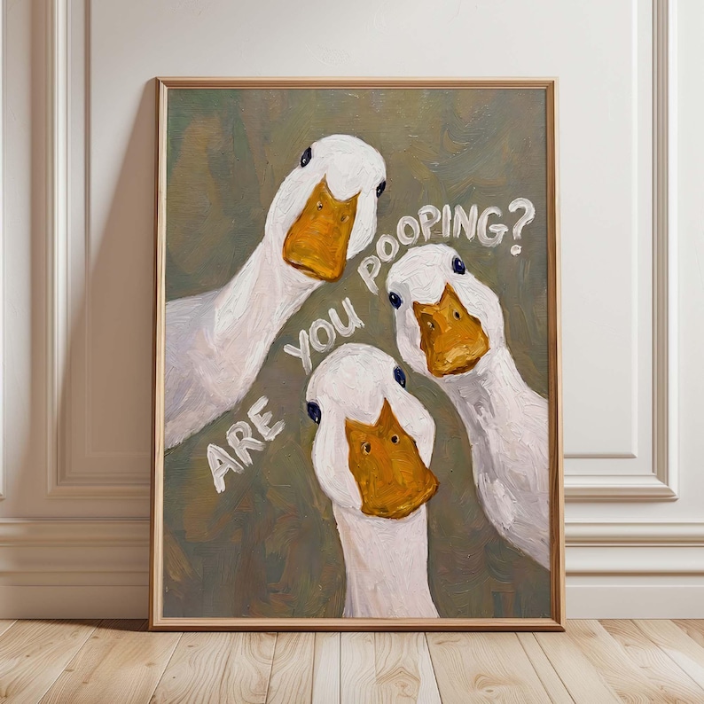 May include: A framed oil painting on canvas featuring three white ducks with orange beaks looking forward against a muted olive green background. The white text "ARE YOU POOPING?" is painted in a curved arrangement between the duck heads.