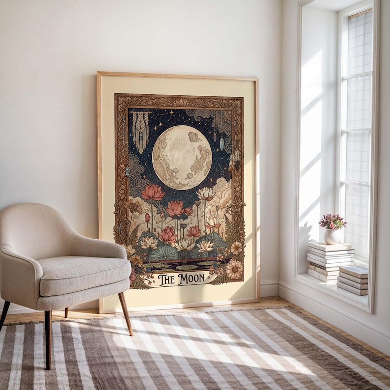 May include: A framed art print depicting the moon, lotus flowers, and celestial details. The artwork has a vintage style with a dark blue night sky and the text "The Moon". The print is displayed in a room with a chair and a striped rug.