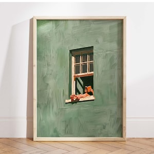 May include: A framed art print depicts a person reading a book in a window. The artwork features a green wall with a window frame, and the person's feet and hands are visible. The book is orange, and the frame is light wood.