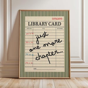 Può includere: Una stampa artistica incorniciata con un design a scheda di biblioteca vintage con sfondo color crema, strisce verticali verde scuro e il testo "LIBRARY CARD" in alto. Il centro mostra la frase scritta a mano "just one more chapter..."